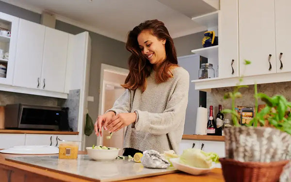 Kvinna som går på GI diet lagar en sallad i ett kök