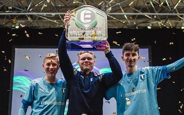 3 yngre killar från MFF E-Sport håller upp guldpokalen för E-Allsvenskan i FIFA