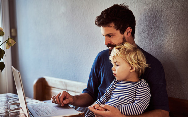 pappa och son tittar på en datorskärm och läser om ärftlig diabetes