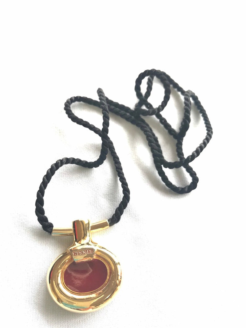 image of HERMES Vintage golden and red stone charm pendant top necklace with black strings