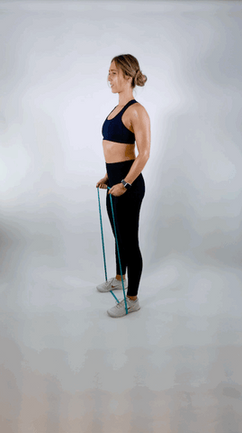A woman performing bicep curls using resistance bands