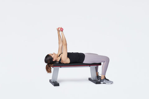 A woman doing chest press with dumbbells