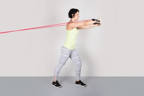 Image of woman doing chest press using resistance bands