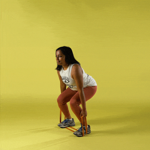 A woman performing deadlifts using resistance bands