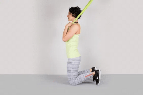 A woman doing kneeling crunch using resistance bands