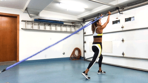 Image of woman doing overhead triceps extension using resistance bands