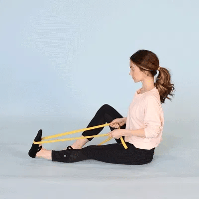 A woman doing plantar flexion using resistance bands