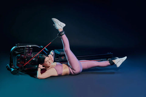 A woman doing Reformer pilates using LIT Pilates Reformer machine