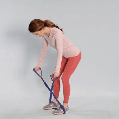 A woman performing reverse fly using resistance bands