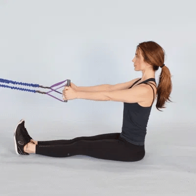 A woman performing seated row using resistance bands