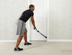 A man doing standing back row (variation) using resistance bands