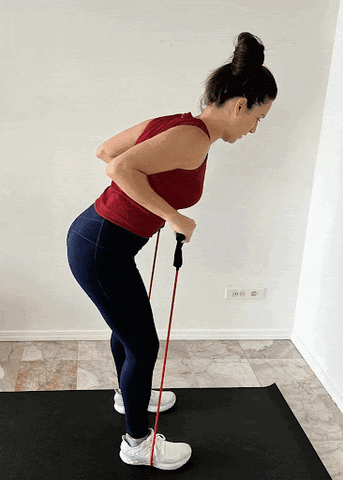 A woman doing tricep kickback workout with resistance band