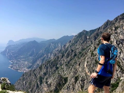 man wearing trail running vest looks out over Riva Del Garda 