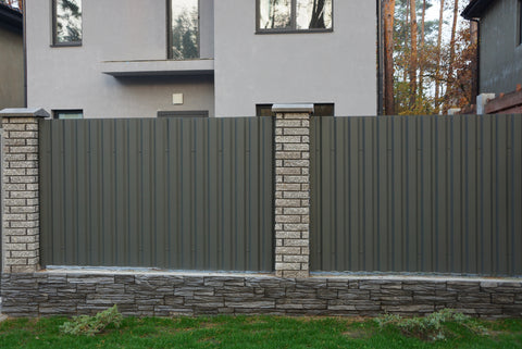 Brick columns interspersed with white vinyl fencing panels, combining traditional and modern elements to provide a sturdy and aesthetically pleasing boundary around a property