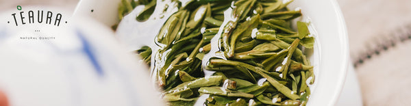 Green tea leaves inside a white teacup