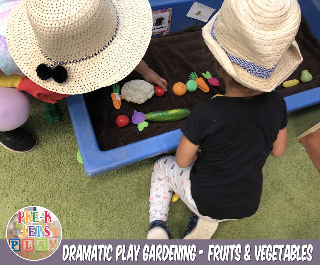 Children using imaginative play to plant and grow plastic toy fruits and vegetables in their pretend garden.