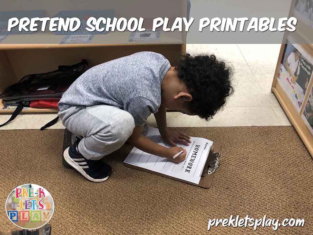 Student writing in pretend school dramatic play. He is doing homework for pretend play. This is a great writing activity.