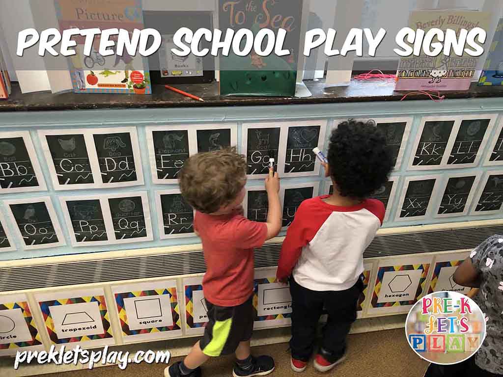 Students reviewing abc alphabet signs from the pretend school dramatic play area. For pretend, they are teaching preschool by reciting the letters of the alphabet.