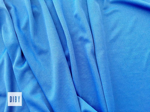 A bright blue piece of ponte fabric draped on a table.