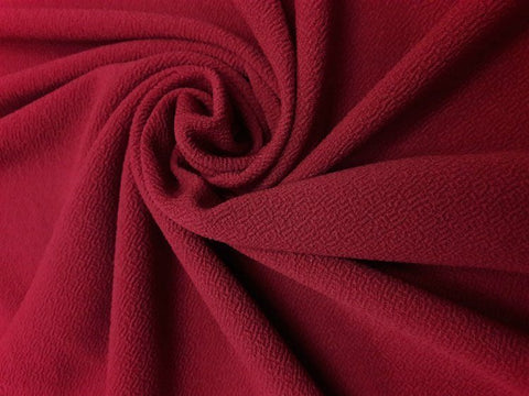 A piece of red liverpool fabric arranged in a swirl.