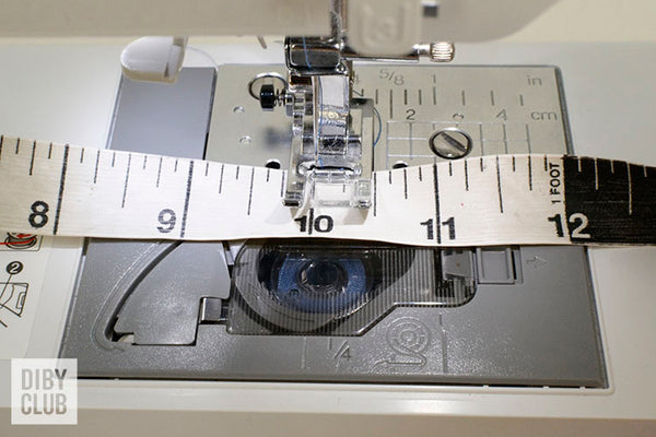 Picture of measuring tape being used to measure seam lines of a sewing machine