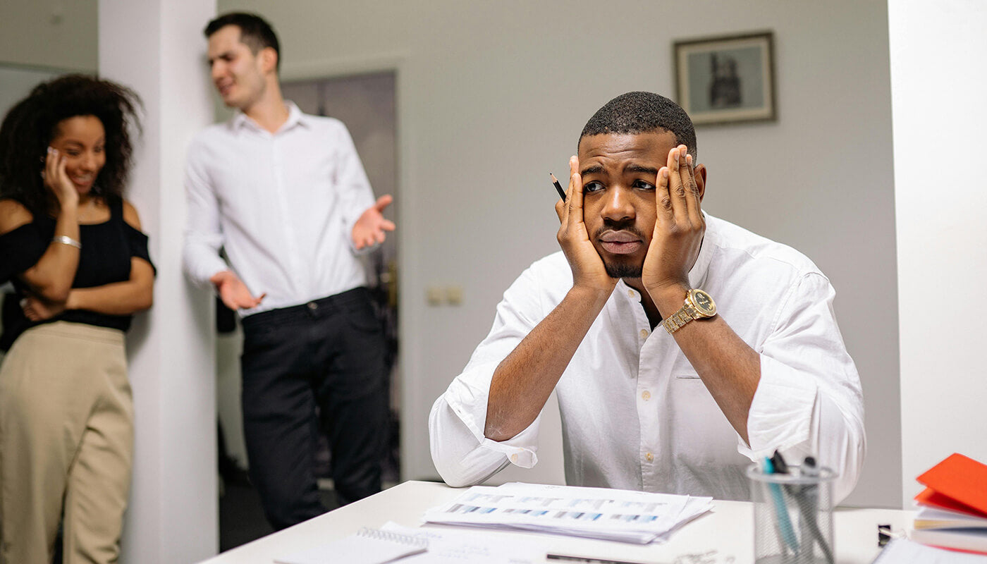 overwhelmed man sitting at desk as anxiety rises from prolonged work