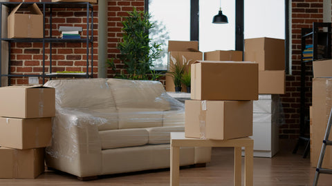 o people in living room interior to move in with carton boxes, empty real estate property full of cardboard showing free furniture delivery service in auckland