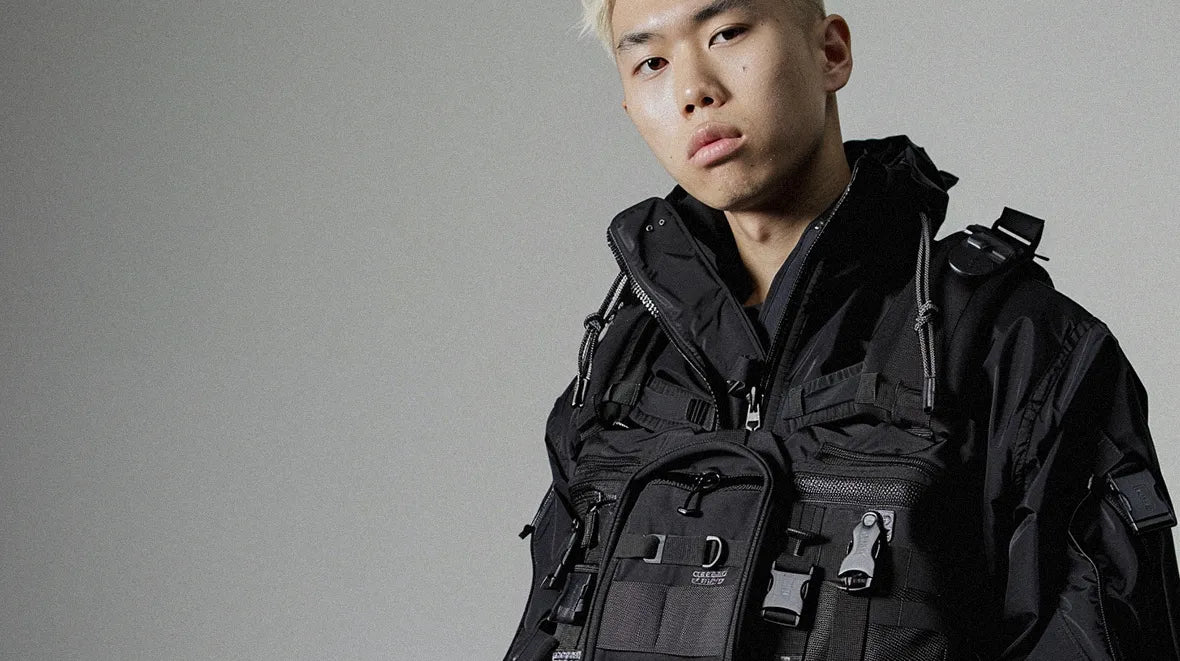 Man with blond hair in a tactical vest and black jacket
