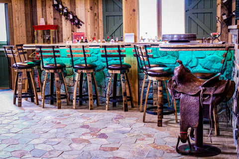 Whiskey Barrel Stools around Stone Bar