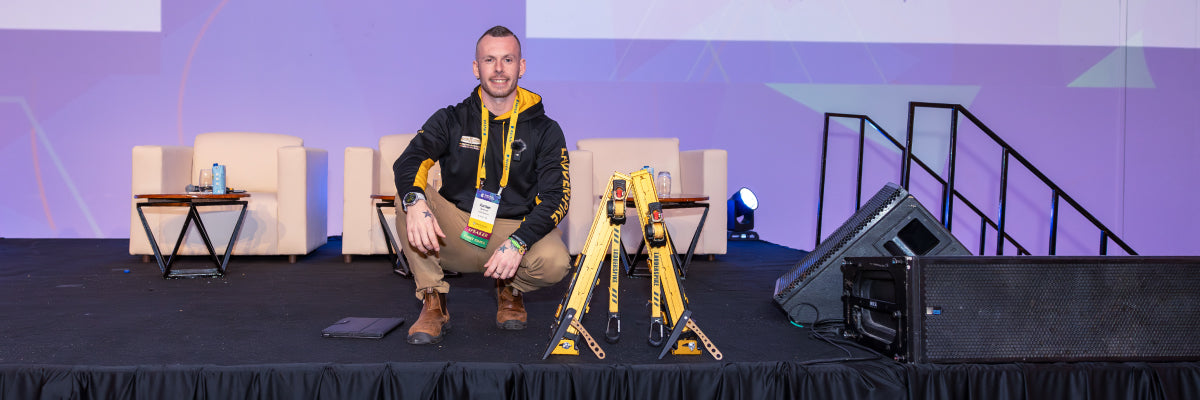 Jordan Spencer sitting on a stage with the Ladder Evolution-Pro