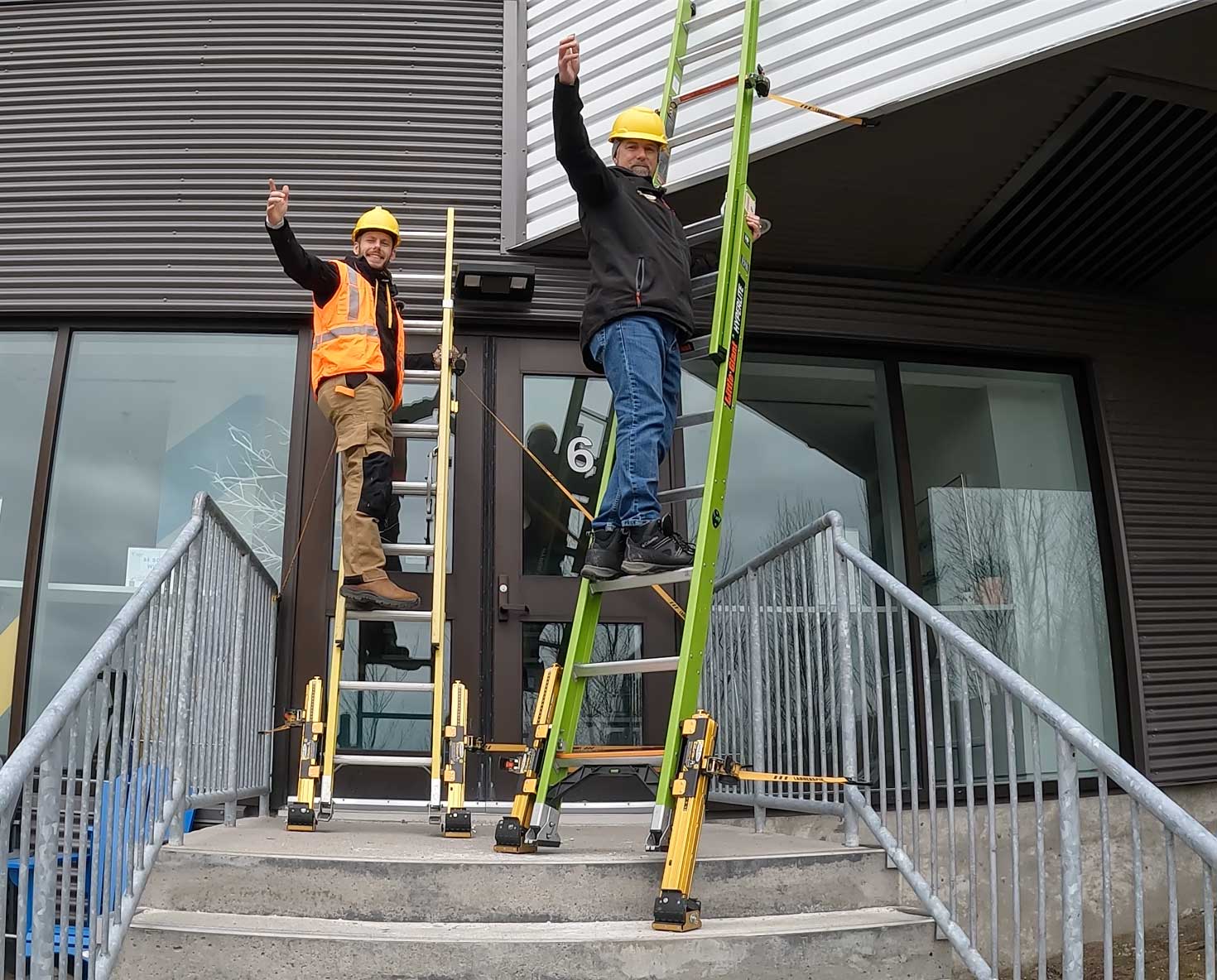 2 workers on a ladder confidently