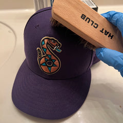 brushing a baseball cap