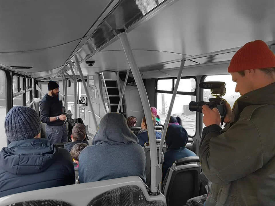 During a Bus Combatives seminar, Julien Masson is seen passionately explaining concepts to his teaching group, all seated on a bus