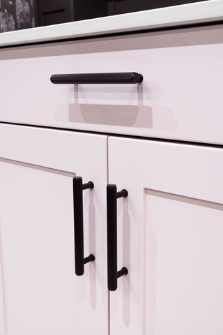 Black reeded door pulls on a pink shaker style kitchen cabinet