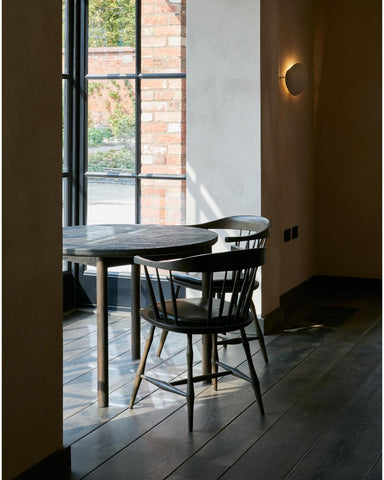 An empty table in a sunlit window on an engineered wood floor