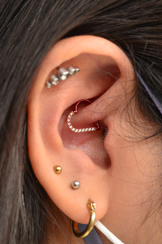 Daith inner ear piercing with a gold heart shaped hoop