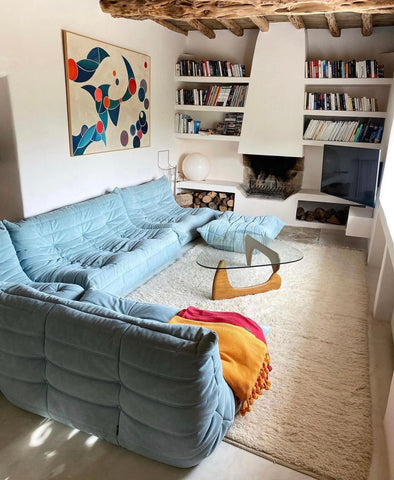 blue togo sofa in cosy livingroom with bookshelves