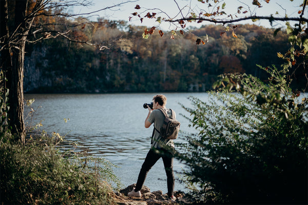 Travel photographer capturing serene lakeside views, embodying the spirit of adventure photography for a travel blog
