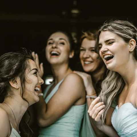 vier Freundinnen lachen gemeinsam auf einem JGA