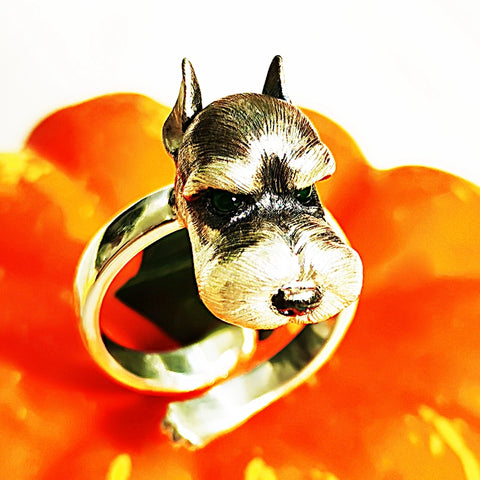 Close-up of a handcrafted Schnauzer pendant and ring set, made from 925 sterling silver with detailed fur texture and gemstone eyes, perfect for pet memorial jewelry.