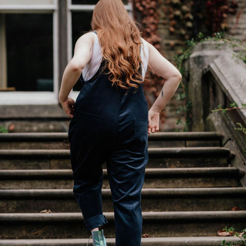 Corduroy dungaree in dark blue. Curved feminine shape. Deep pockets. Adjustable strap fastening.