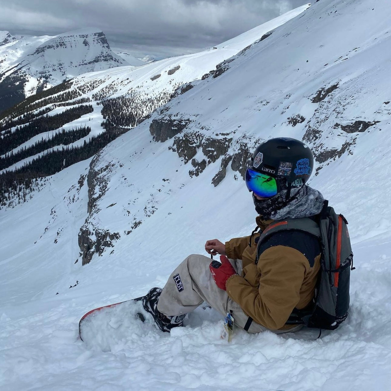 photo of snowboarder sitting on mountain