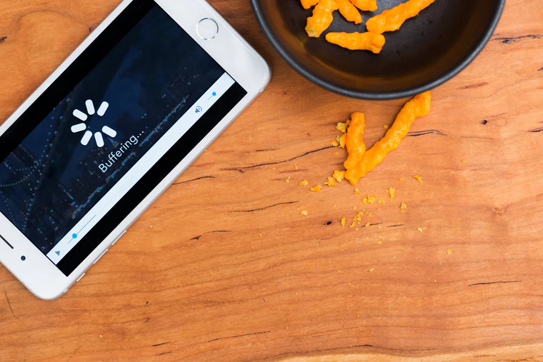 Mobile phone resting on a table and showing 'Buffering...' with a loading indicator