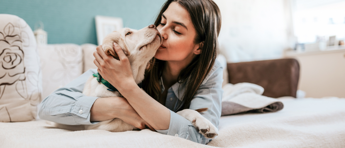 dog in bed with woman to help her sleep better