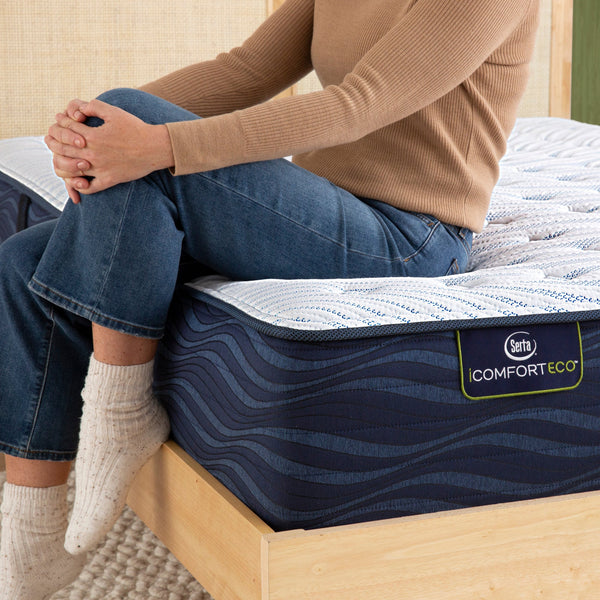 Person Sitting On Serta iComfortECO Quilted Hybrid Medium Mattress