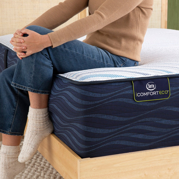 Person Sitting On Serta iComfortECO Smooth Hybrid Medium Mattress