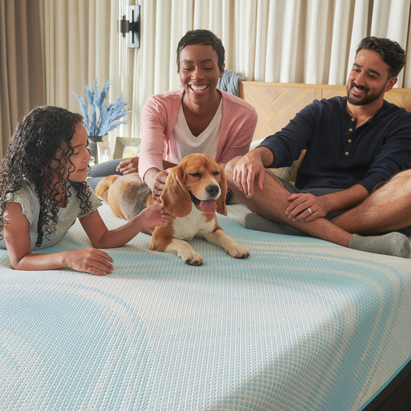 Family sitting on Tempur-Pedic Tempur-LuxeBreeze 2.0 Medium Hybrid Mattress