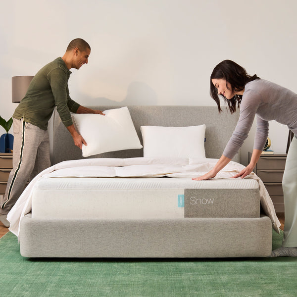 Couple putting sheets on a Casper Snow Mattress