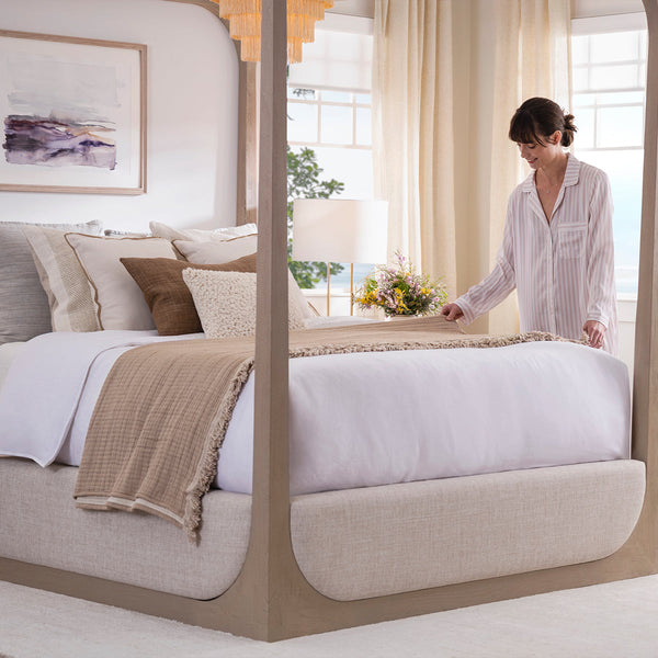 Woman putting blankets on Purple Restore Premier Soft Mattress