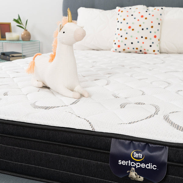 Sertapedic® Elkridge Euro Top Mattress by Serta Closeup Shot With Unicorn Plushies. Product Fabric Detail And Lbael.